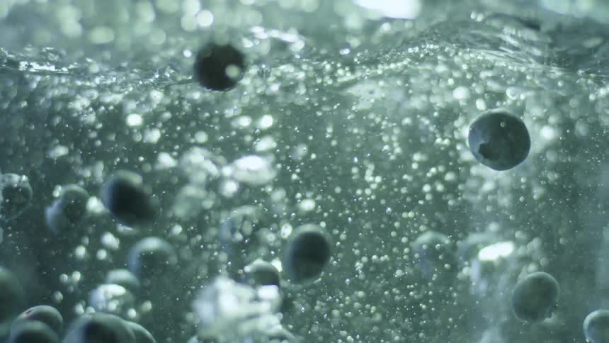 Blueberries falling into boiling water