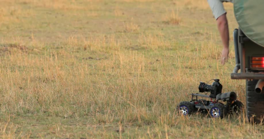 A man adjusts the camera on a radio controlled car