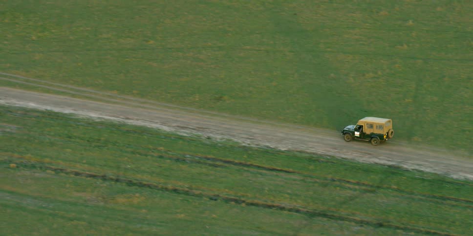 A jeep traveling down a rural dirt road