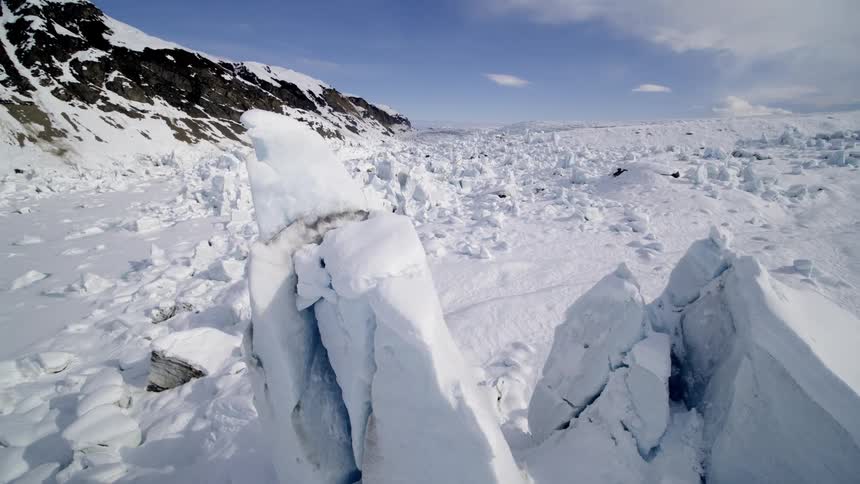 Snow covered plain stretches to horizon near mountain