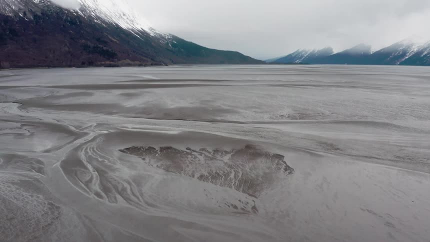 A frozen lake sits in the middle of a mountain valley