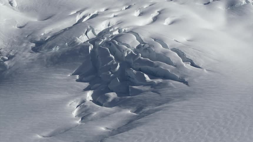 Snow and ice breaks on the surface of frozen water
