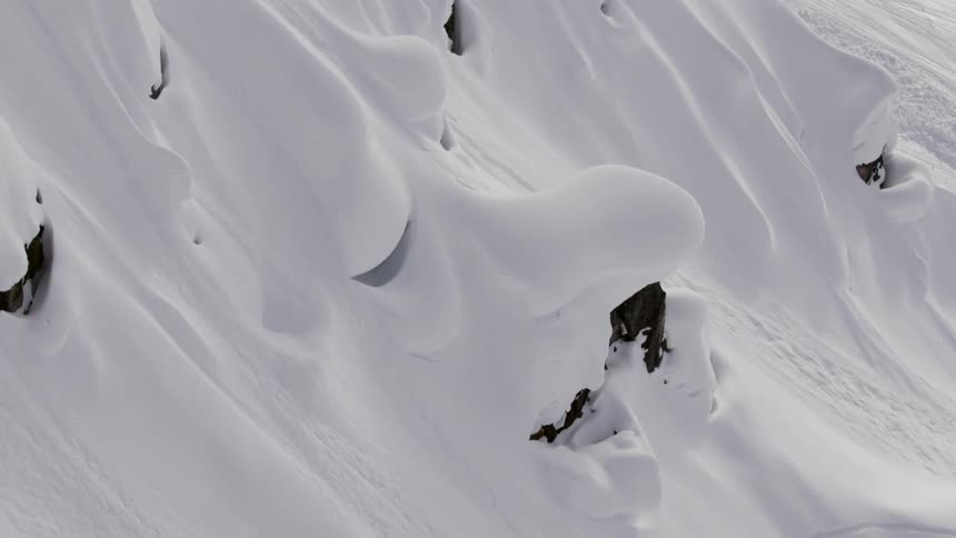 The mountain slope is covered in heavy snow