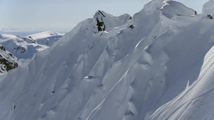 A high mountain covered in deep snow drifts