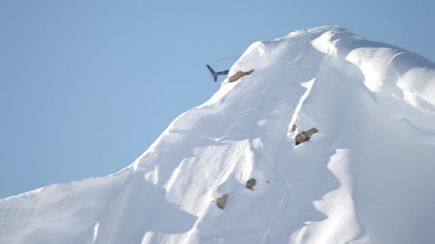 A helicopter flying over a snow covered mountain