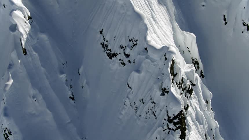 Snow covers ridge bordered by shadowy ravines