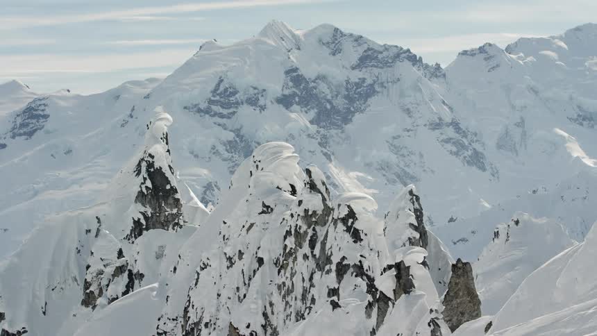 Snow covers rocky mountain peaks in the wilderness
