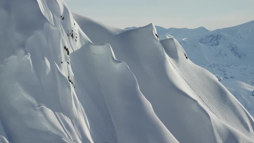 A snow covered mountain range with the sky in the background