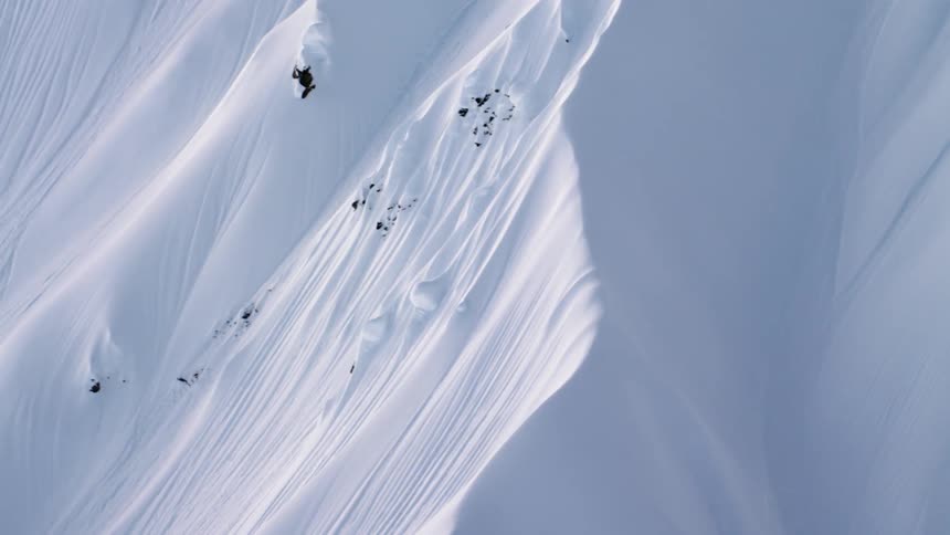 Snow falls into a slope with multiple ridges