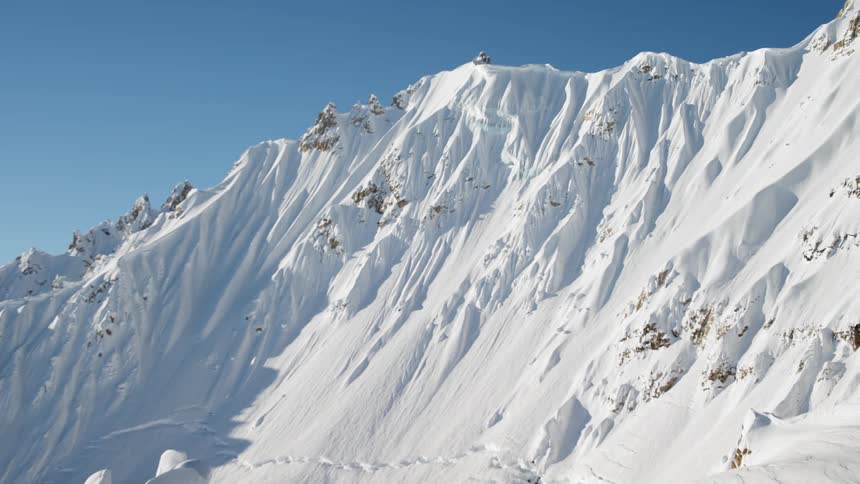 A mountain covered in snow with the sky in the background