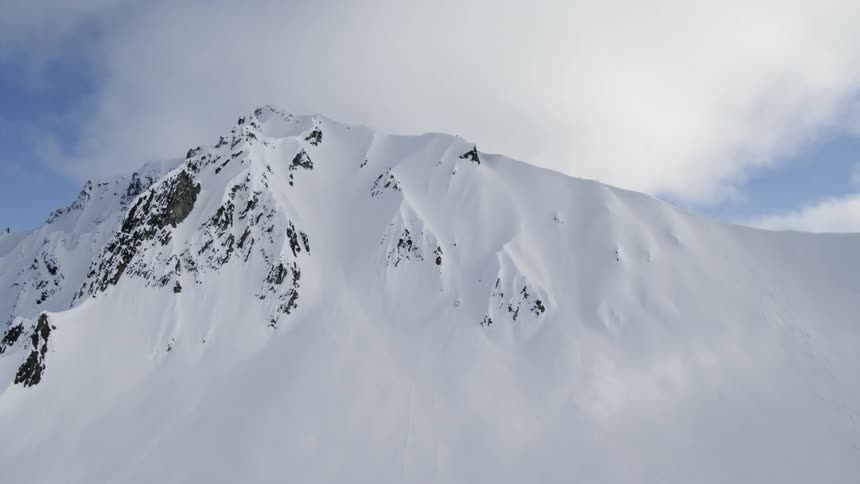 Tall snowy mountain peak against sky