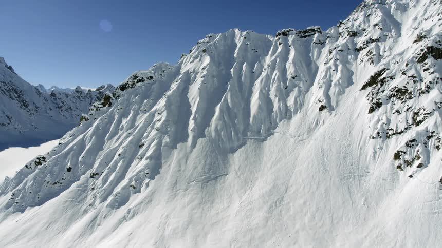 A snow covered mountain ridge under a clear sky