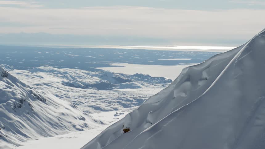 A mountain covered in snow with the sky in the background