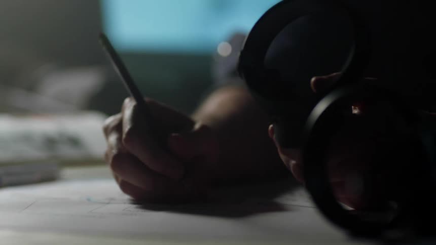 A person with a pencil writing on a paper