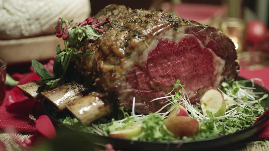 Cooked meat roast sits on the platter surrounded by garnish