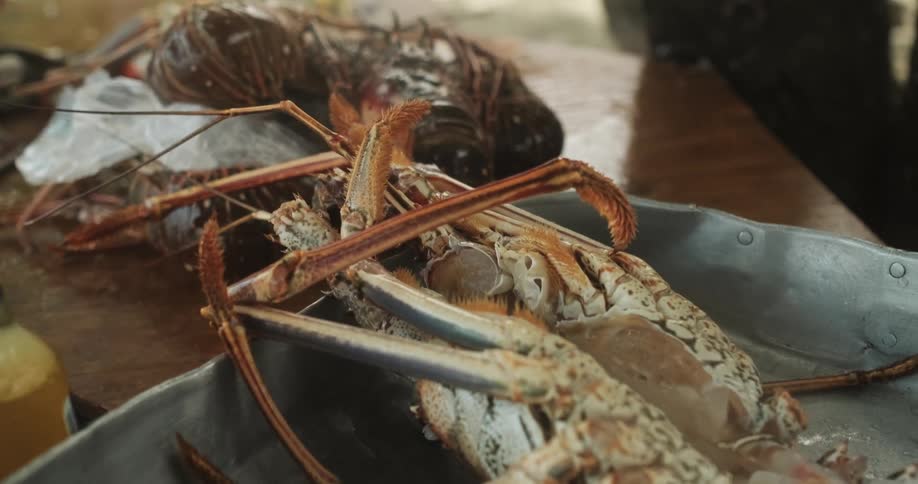 Fresh lobster in metal pan on wooden table