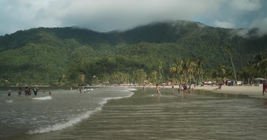 People playing in waves on a tropical beach