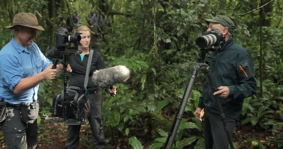 Camera crew standing in a green wooded area