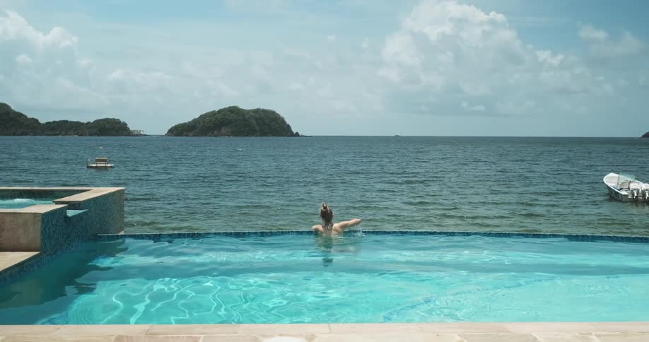 Woman looking out over ocean in a pool