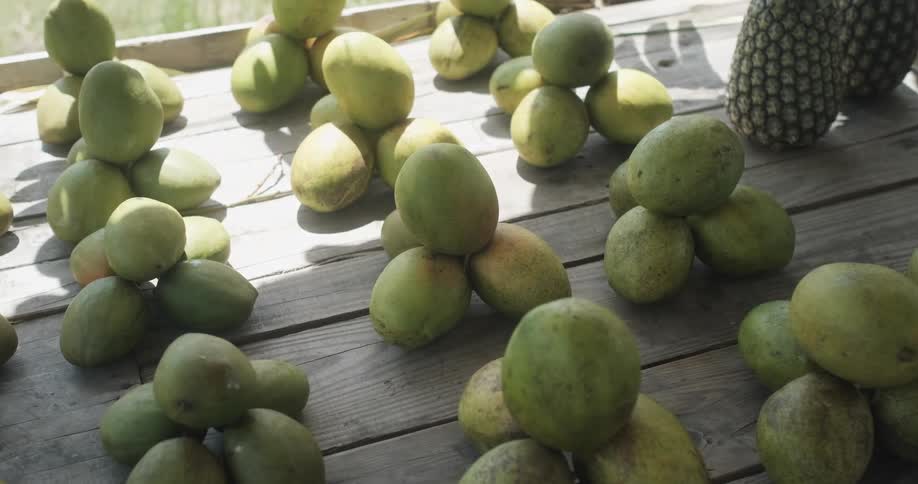 Mangos sitting on a table in a market