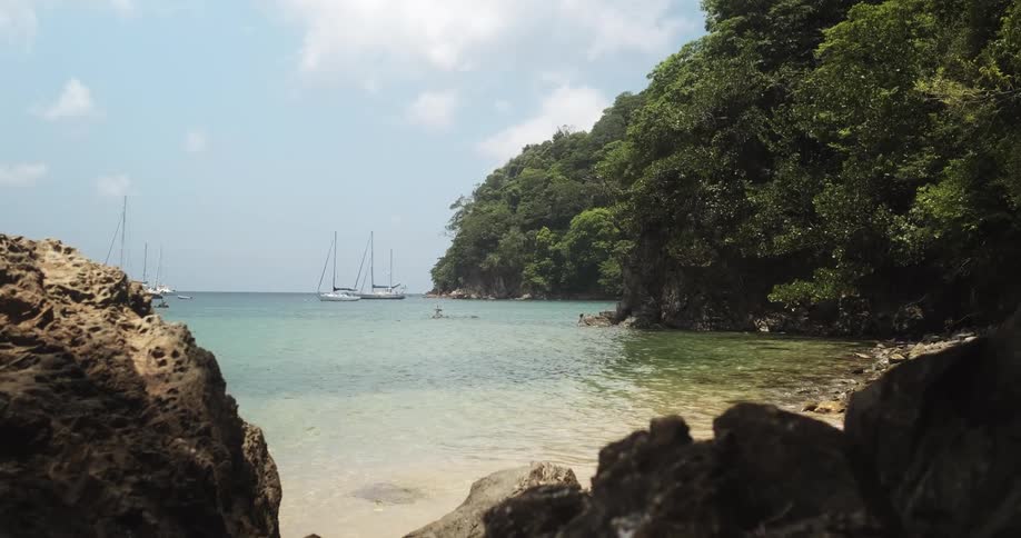 Sailboats anchored on island beach