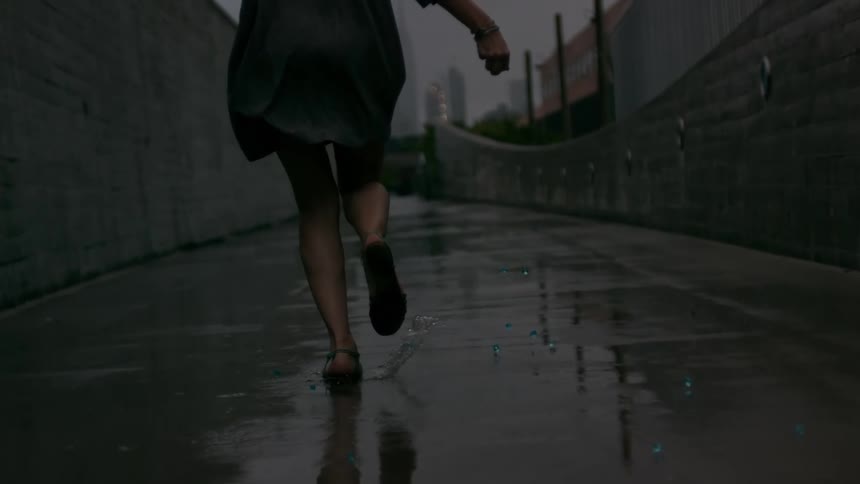 Woman runs on a wet city street dropping jewelry on the floor