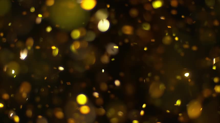 Glitter slowly falls in the dark room