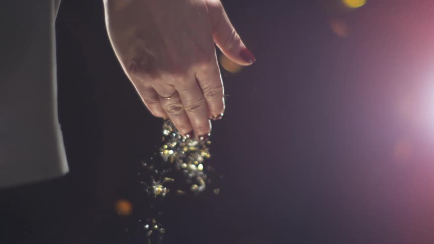 A womans hand opens and glitter confetti falls