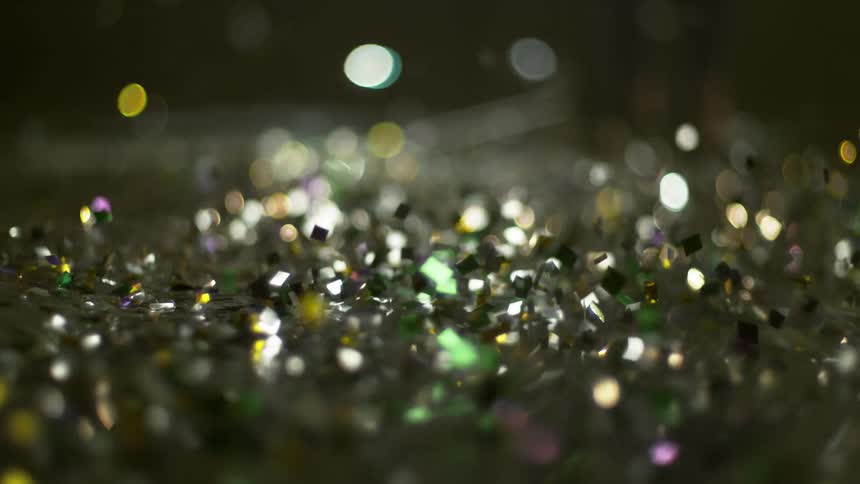Sparkling glitter bouncing on a surface reflecting colorful lights