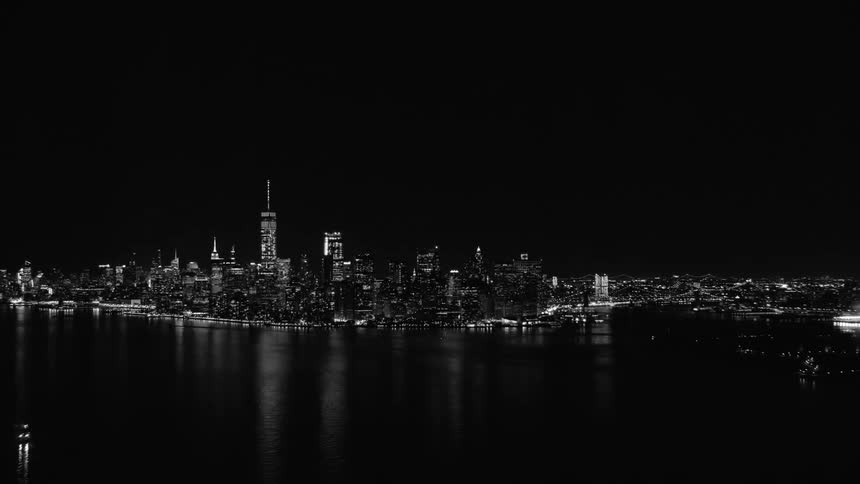 City skyline reflected on the dark water at night in a black and white contrast