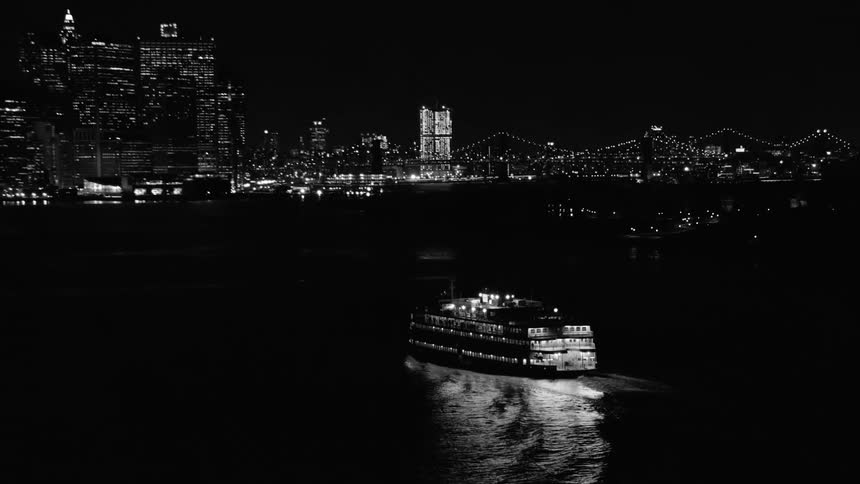 A ferry in the water with the city skyline in the distance