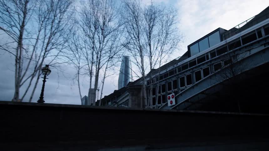 A bridge with trees with buildings in the background