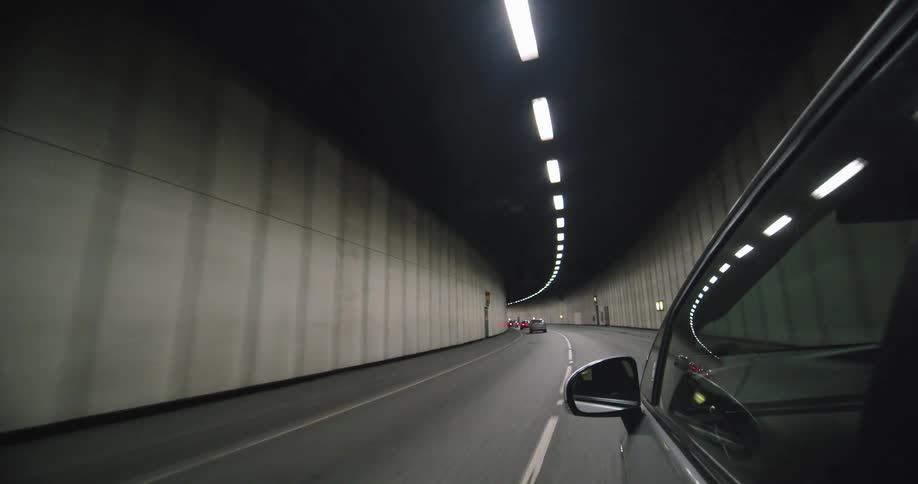 Fast car drives on a tunnel with low traffic