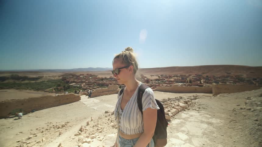 A woman walks through a desert