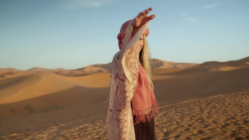 Woman in a dancing outfit does dance moves in the desert