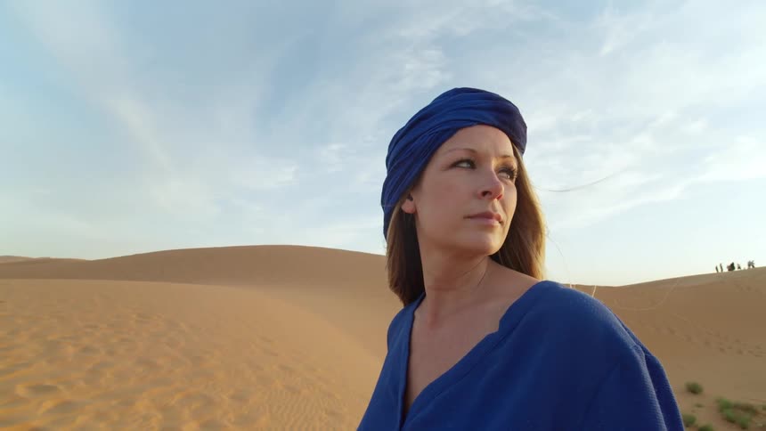 A woman looks around in the desert