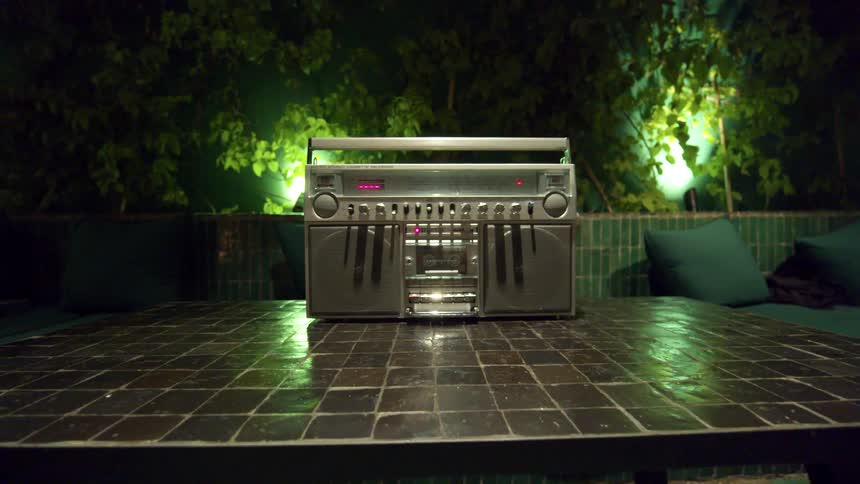 A vintage radio sits playing on the table