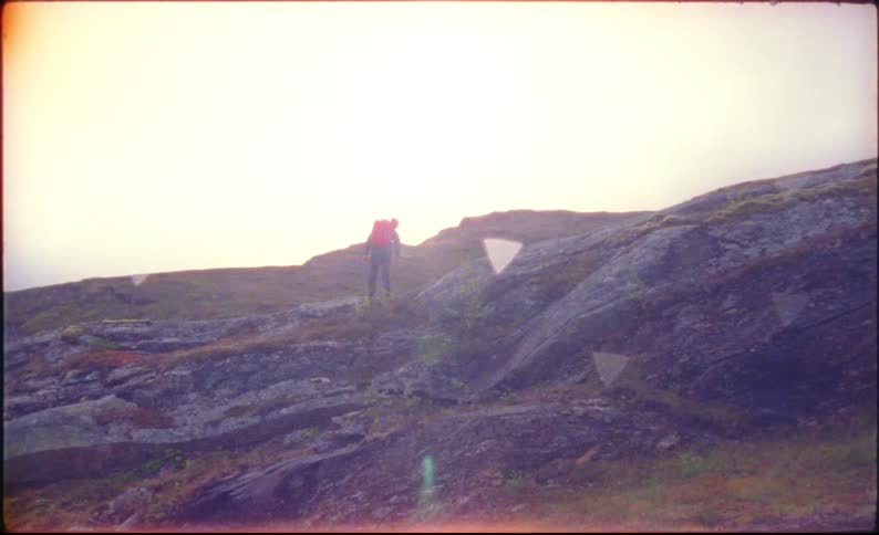 A hiker climbs a rocky hill