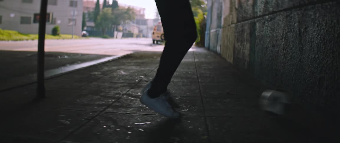 A person kicks a soccer ball against a wall in a tunnel in the city