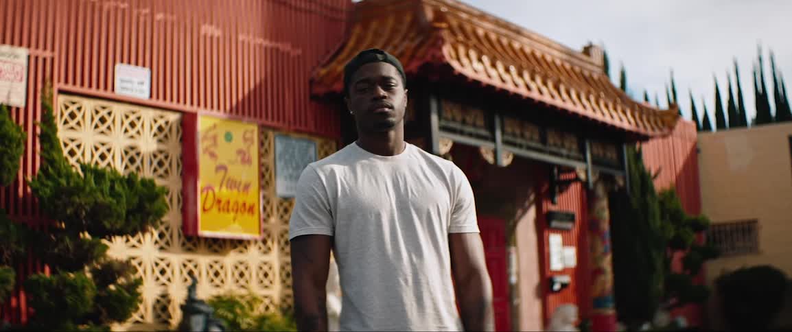 Black man stands in front of an asian temple