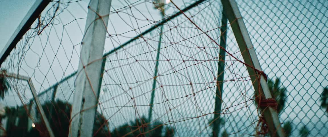 A soccer ball flying into the back of the net of a soccer goal
