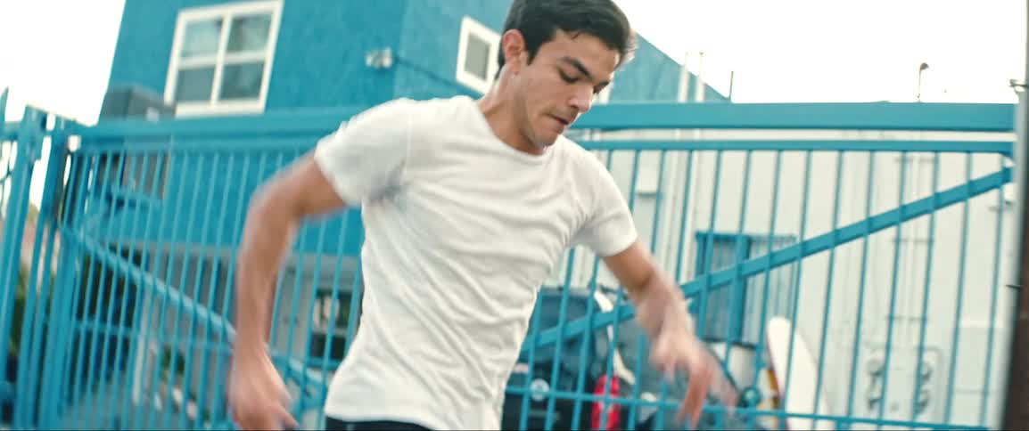 The boy runs while he kicks the soccer ball