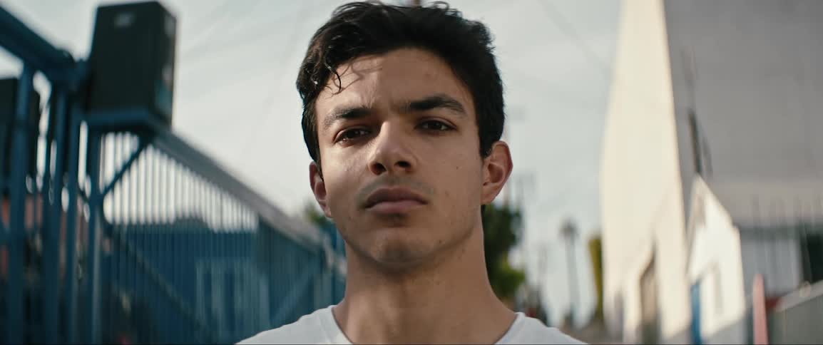 A hispanic man stands in an alley