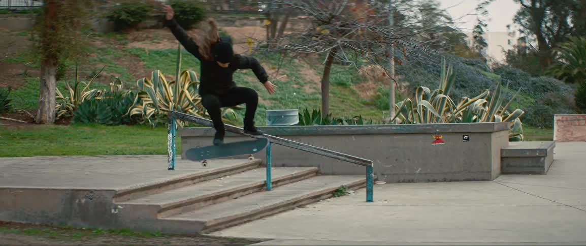 A girl on a skateboard jumps down stairs
