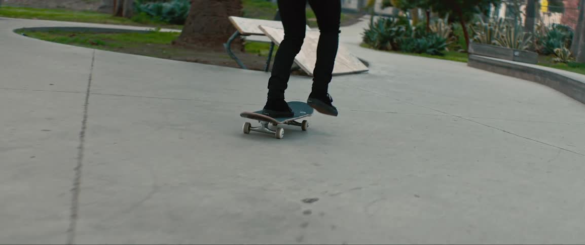 Teenage girl riding skateboard through urban skate park
