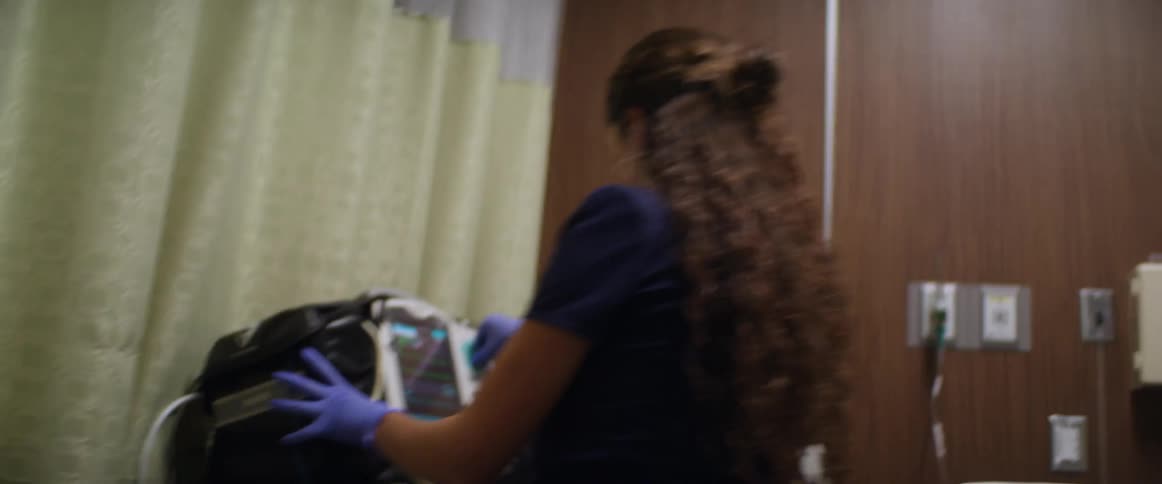 A nurse works to help a patient in a hospital