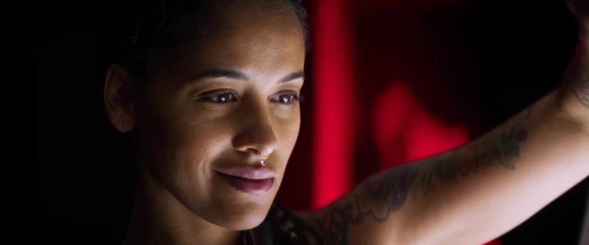 A woman holds something up and smiles