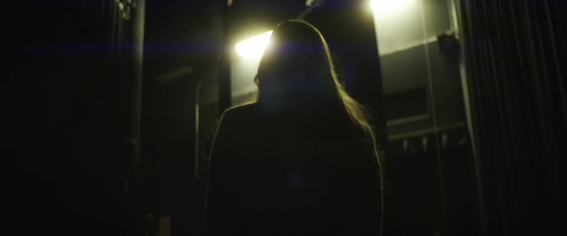 A woman is walking in a city at night