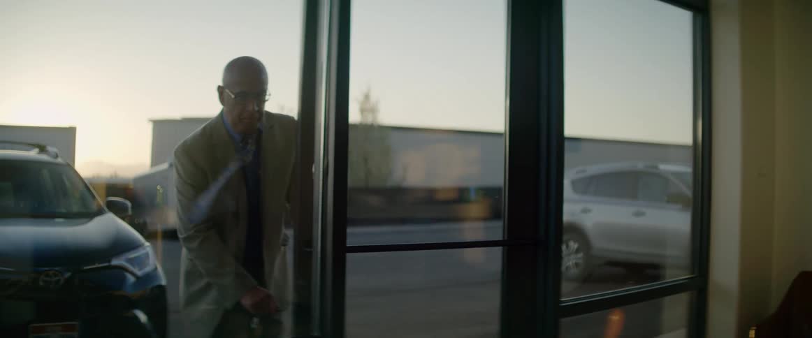 Older man unlocking office front door and walking in