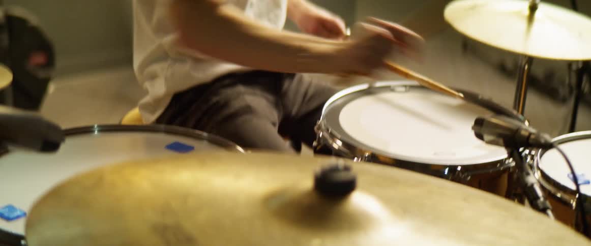 A man is playing drums indoors